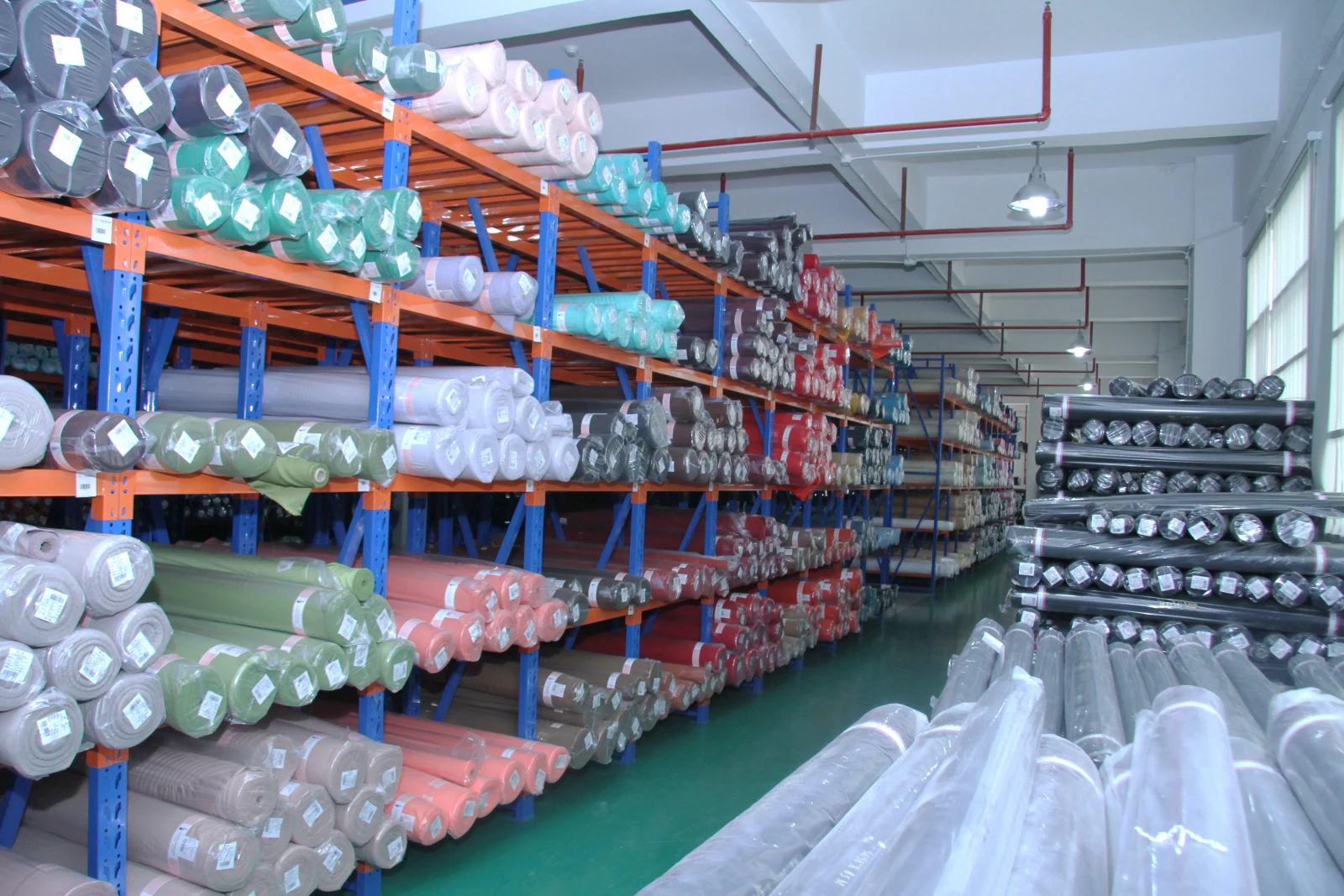 Fabric rolls organised by colour and material in storage
