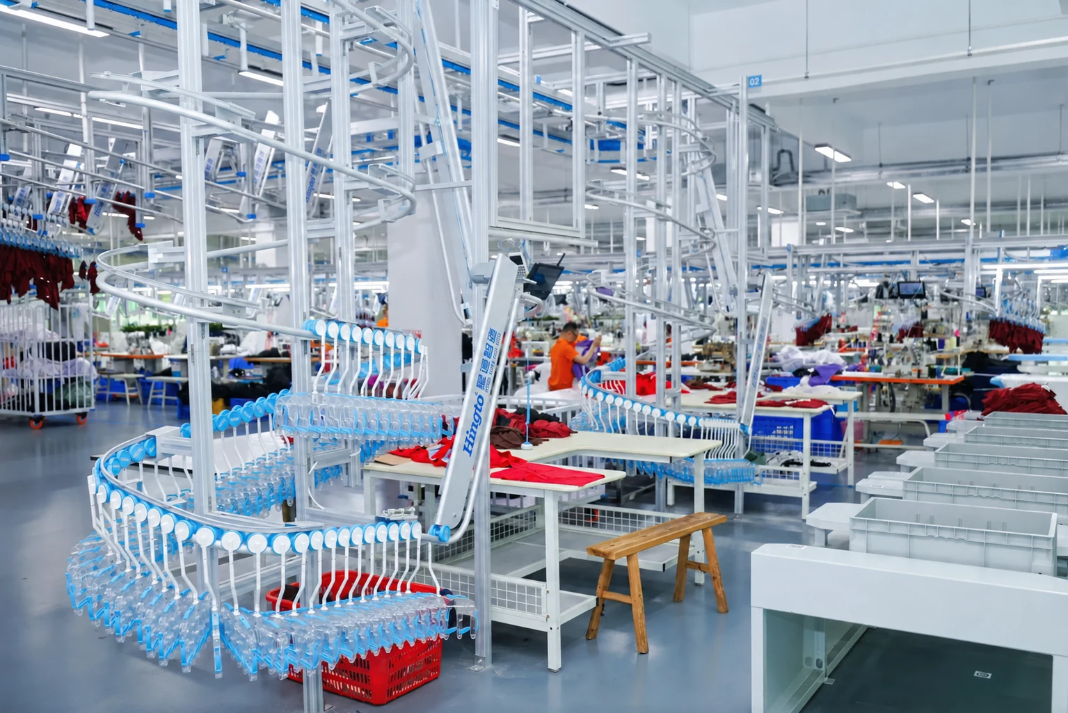 Garment production floor with overhead handling rails and sewing workstations